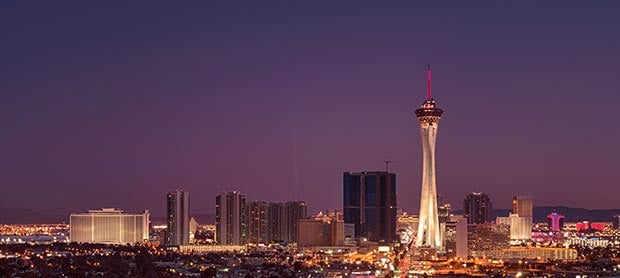 A cityscape at dusk with a prominent tower in the center