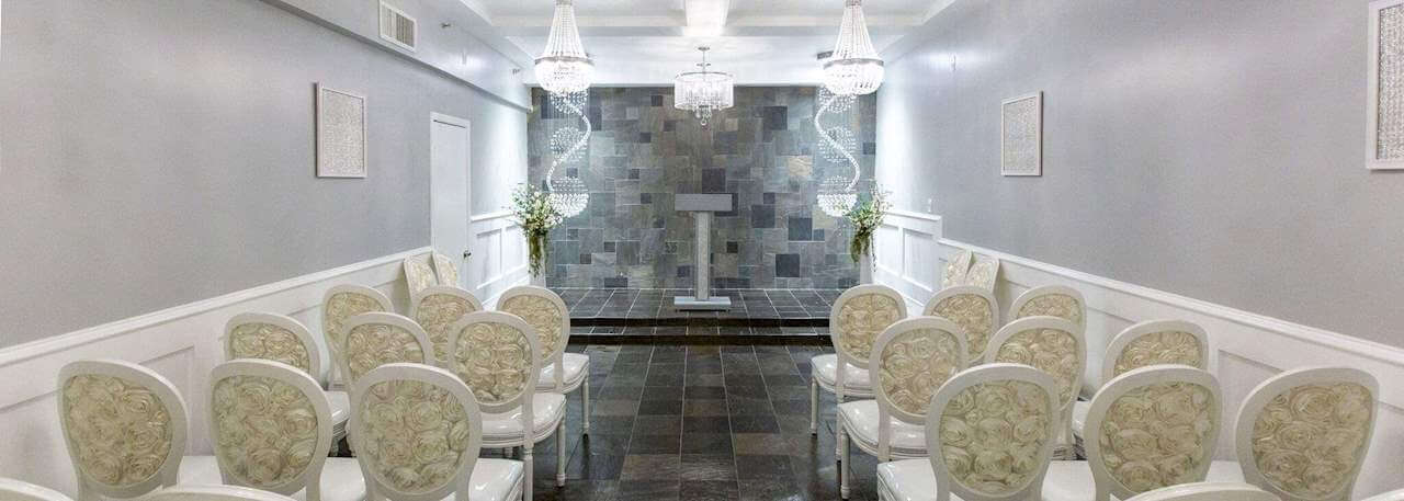 a small meeting room with white walls, a tile floor, and rows of chairs