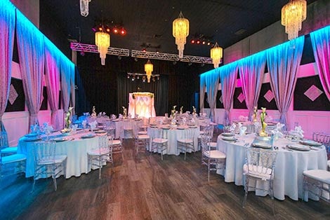 a large room with round tables and white chairs set for dining